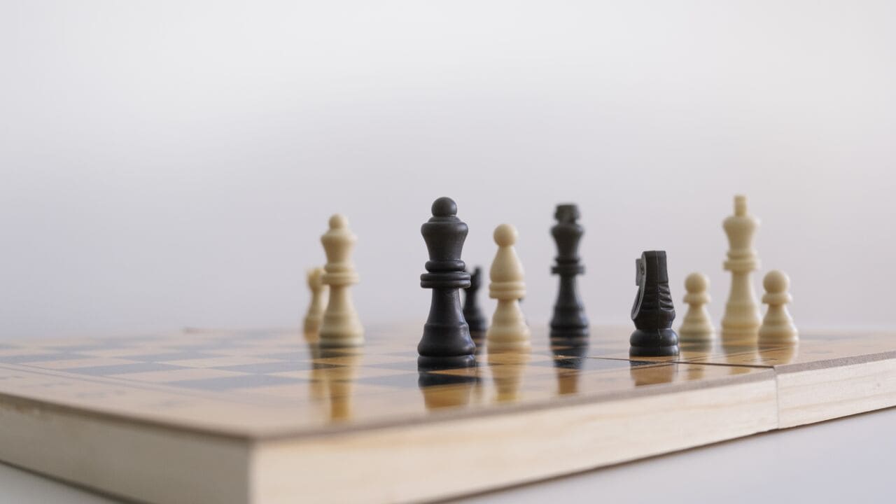 Closeup Shot Of Chess Figurines On A Chessboard With A Blurred White Background Closeup Shot Of Chess Figurines On A Chessboard With A Blurred White Background