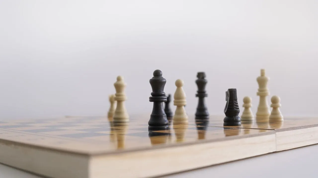 Closeup Shot Of Chess Figurines On A Chessboard With A Blurred White Background