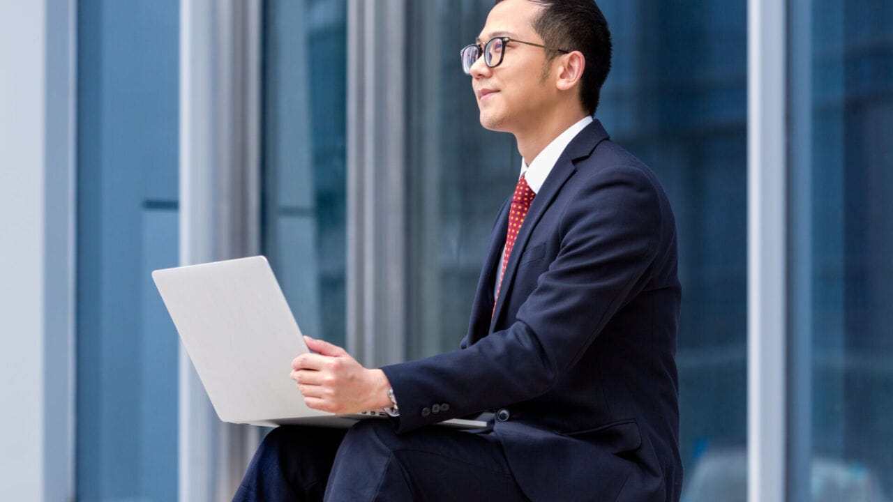 Young Businessman Sitting On Steps And Using His Laptop Young Businessman Sitting On Steps And Using His Laptop