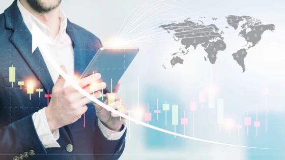double exposure of businessman using the tablet with cityscape and financial graph on blurred building background, business trading concept